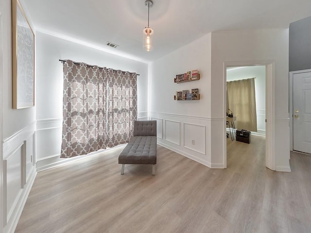 388 Oakhaven Way, Villa Rica, GA 30180 - living area featuring a decorative wall, visible vents, light wood-type flooring, and wainscoting