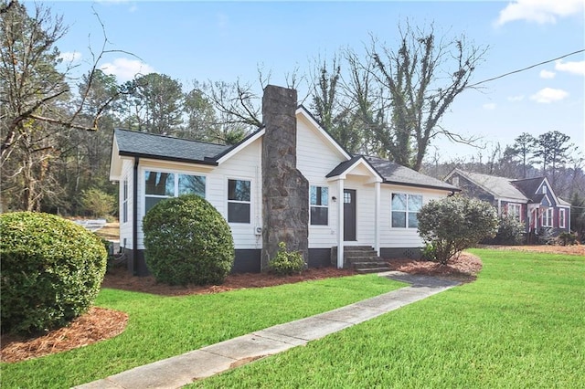 bungalow featuring a front yard, entry steps, and a chimney