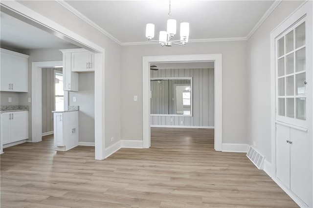 unfurnished dining area featuring a notable chandelier, visible vents, a wealth of natural light, and baseboards