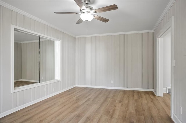 spare room with baseboards, wood finished floors, ceiling fan, and ornamental molding