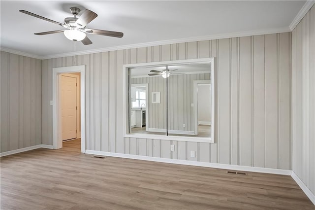 unfurnished room featuring wood finished floors, visible vents, and a ceiling fan