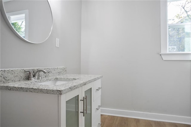 bathroom with wood finished floors, vanity, and baseboards