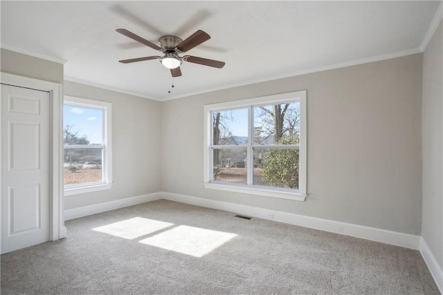 carpeted spare room featuring visible vents, baseboards, and a healthy amount of sunlight