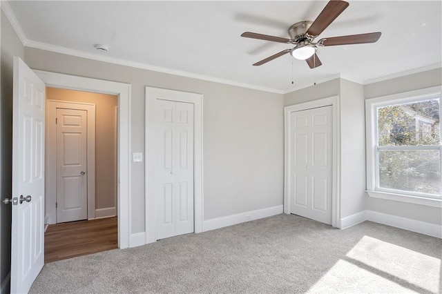unfurnished bedroom featuring crown molding, carpet flooring, ceiling fan, and baseboards