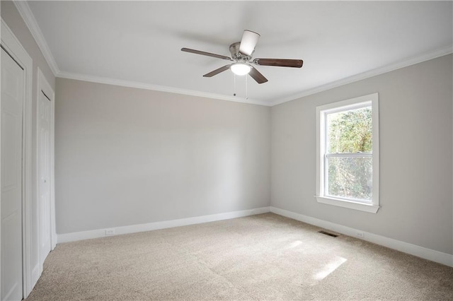 unfurnished bedroom with ornamental molding, visible vents, carpet, and baseboards