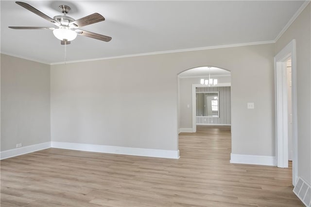 spare room with baseboards, arched walkways, and light wood finished floors