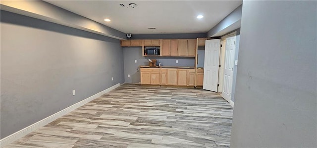 kitchen with light wood-type flooring and light brown cabinets