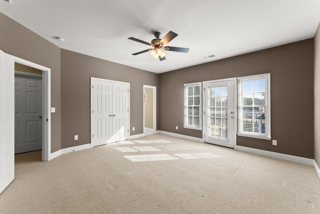 unfurnished bedroom featuring light carpet, access to outside, and baseboards