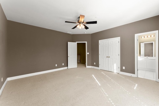 unfurnished bedroom featuring connected bathroom, light colored carpet, visible vents, baseboards, and a closet