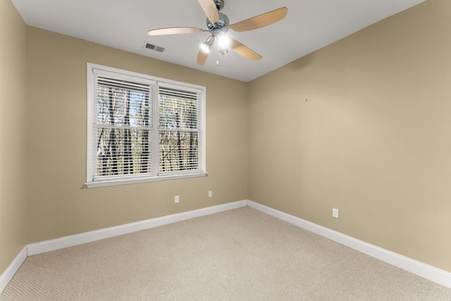 unfurnished room featuring a ceiling fan, light colored carpet, and baseboards