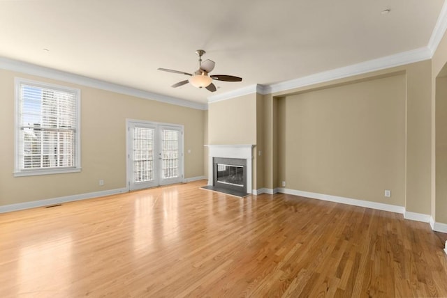 unfurnished living room with ornamental molding, light wood-type flooring, a fireplace, and baseboards