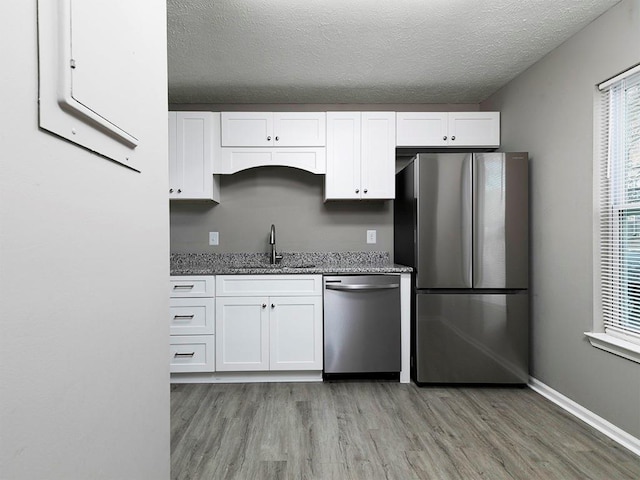 kitchen featuring sink, white cabinets, light wood-type flooring, and appliances with stainless steel finishes