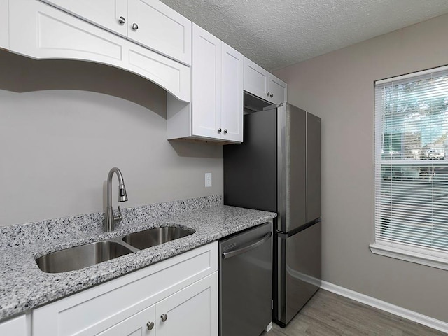 kitchen featuring light stone countertops, white cabinetry, sink, dark wood-type flooring, and stainless steel dishwasher