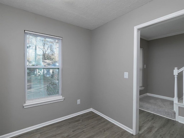 empty room featuring a textured ceiling and dark hardwood / wood-style flooring