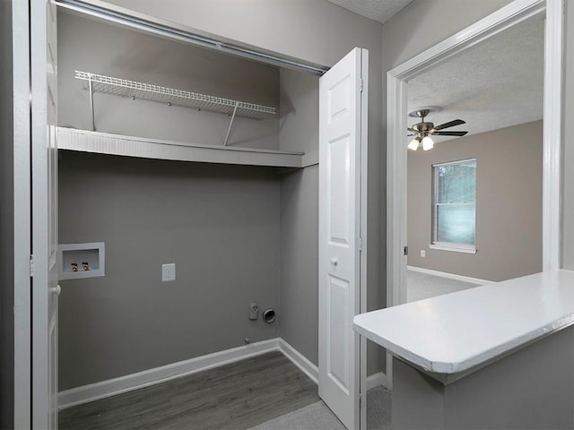 clothes washing area featuring ceiling fan, washer hookup, hookup for a gas dryer, hardwood / wood-style floors, and a textured ceiling