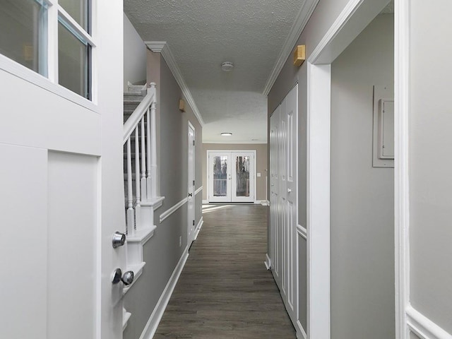 corridor featuring french doors, a textured ceiling, dark hardwood / wood-style floors, and crown molding