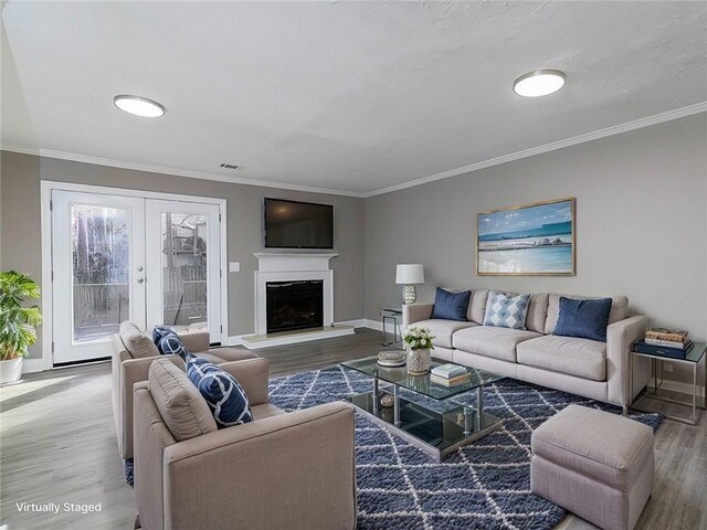 unfurnished living room with a textured ceiling, hardwood / wood-style floors, french doors, and ornamental molding