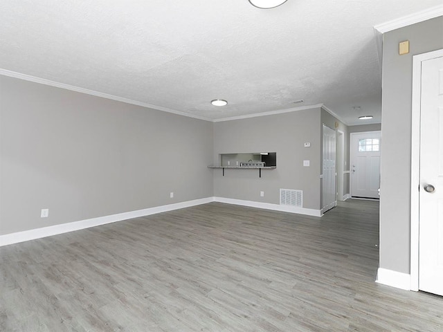 unfurnished living room with a textured ceiling, hardwood / wood-style flooring, and crown molding