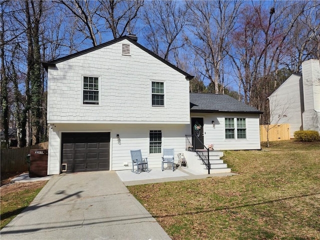 view of front of home with driveway, a front lawn, an attached garage, and fence