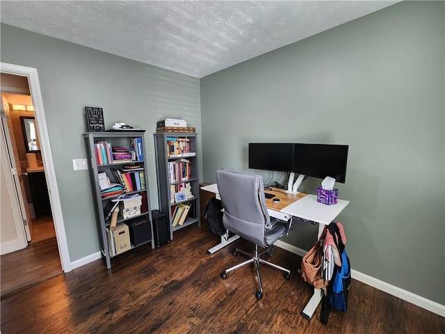 office area featuring a textured ceiling, baseboards, and wood finished floors