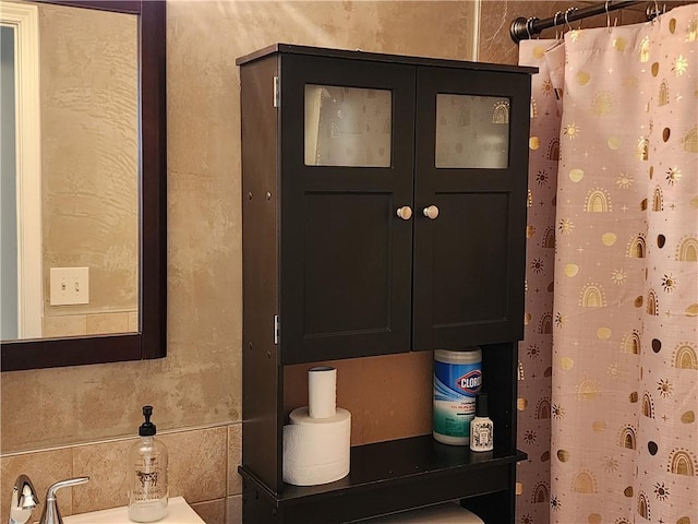 interior details featuring curtained shower and a sink