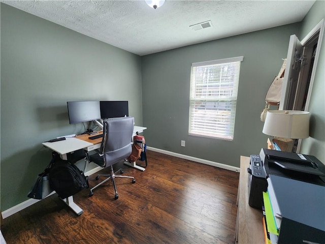 office area with baseboards, visible vents, a textured ceiling, and hardwood / wood-style floors