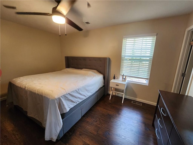 bedroom featuring dark wood-style floors, a ceiling fan, visible vents, and baseboards