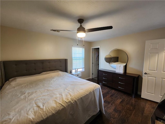 bedroom with a ceiling fan, baseboards, and dark wood-style flooring