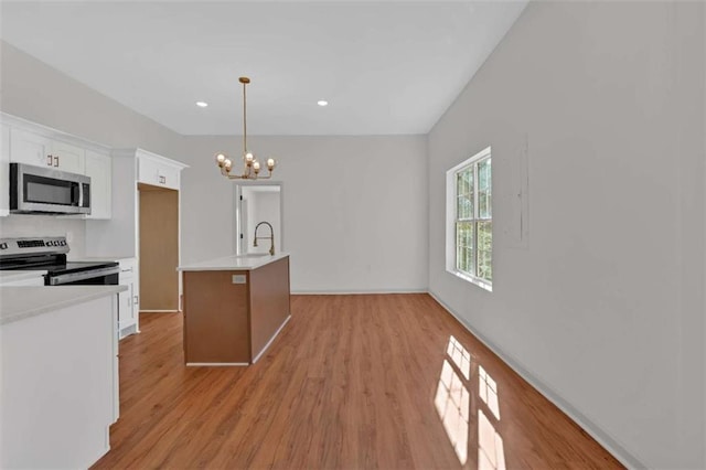 kitchen featuring light wood-style flooring, stainless steel appliances, light countertops, white cabinetry, and a notable chandelier