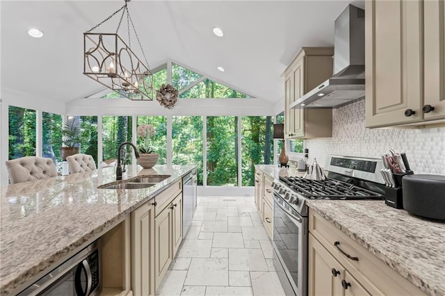 3287 Alton Rd, Atlanta, GA 30341 - kitchen featuring appliances with stainless steel finishes, a sink, cream cabinetry, wall chimney exhaust hood, and vaulted ceiling