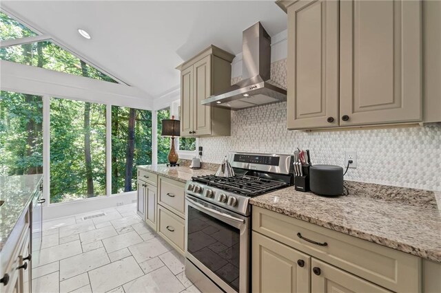3287 Alton Rd, Atlanta, GA 30341 - kitchen with stainless steel gas range, wall chimney exhaust hood, cream cabinetry, vaulted ceiling, and backsplash