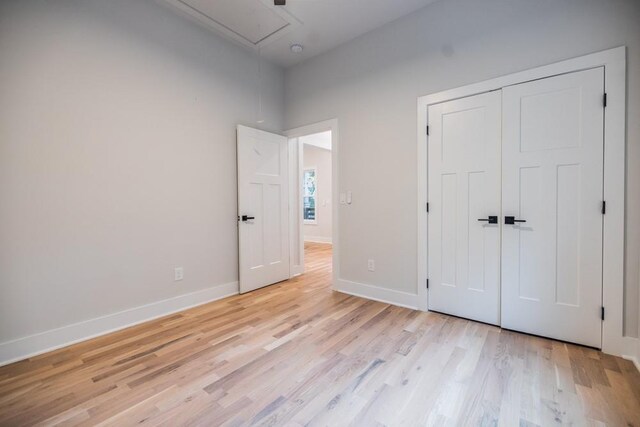 unfurnished bedroom featuring light wood-type flooring and a closet