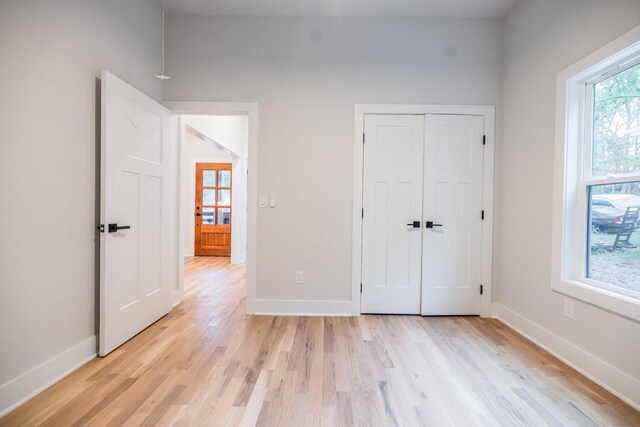 unfurnished bedroom with a closet and light wood-type flooring