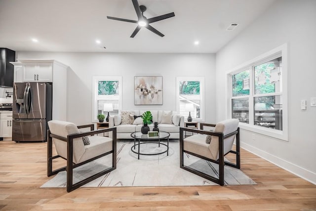 living room featuring light wood-type flooring and ceiling fan