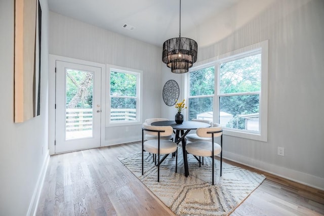 dining room featuring light wood-type flooring and an inviting chandelier