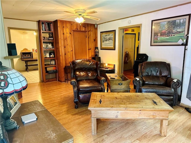 living room with light hardwood / wood-style flooring, ceiling fan, and crown molding