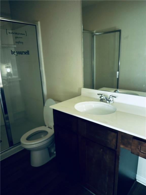 full bathroom with vanity, a stall shower, toilet, and wood finished floors