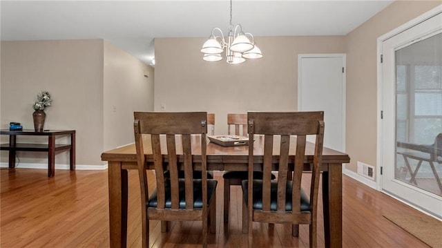 dining room featuring hardwood / wood-style flooring and a notable chandelier