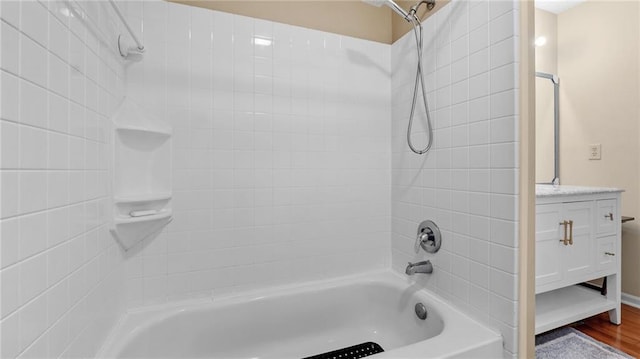 bathroom featuring vanity, wood-type flooring, and tiled shower / bath