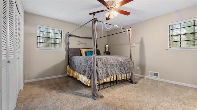 bedroom featuring a closet, ceiling fan, carpet floors, and multiple windows