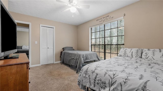 bedroom with ceiling fan, light colored carpet, and a closet