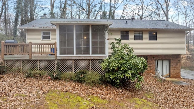 rear view of house with a sunroom and a deck