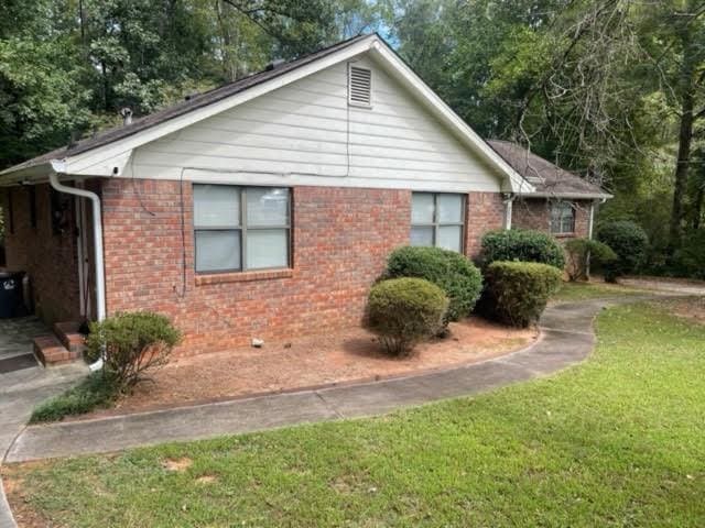 view of side of home with a yard