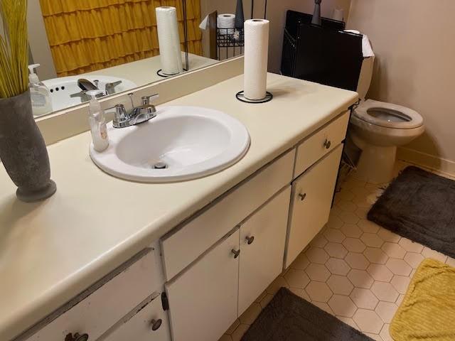 bathroom featuring vanity, toilet, and tile patterned flooring