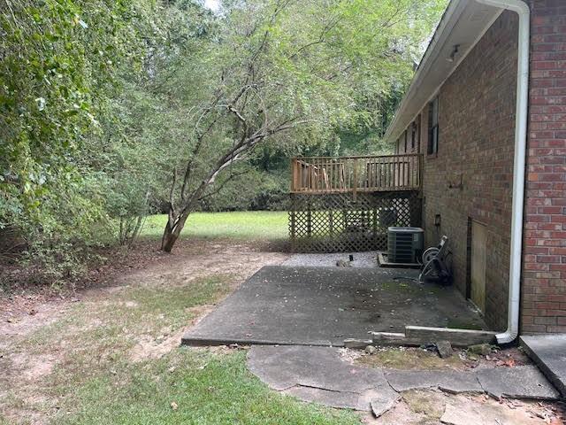 view of yard featuring a wooden deck and central air condition unit