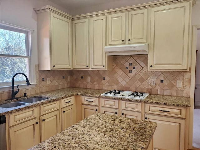 kitchen with white gas cooktop, sink, tasteful backsplash, cream cabinets, and stainless steel dishwasher