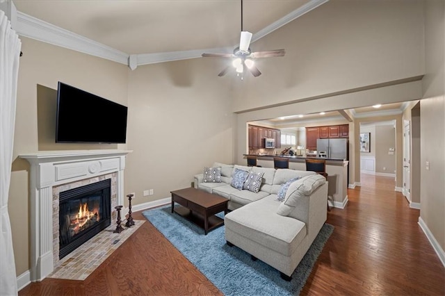 living area featuring ornamental molding, dark wood-type flooring, a tile fireplace, and baseboards