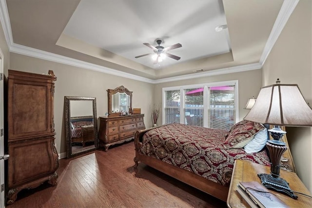 bedroom featuring hardwood / wood-style flooring, ceiling fan, a raised ceiling, and crown molding