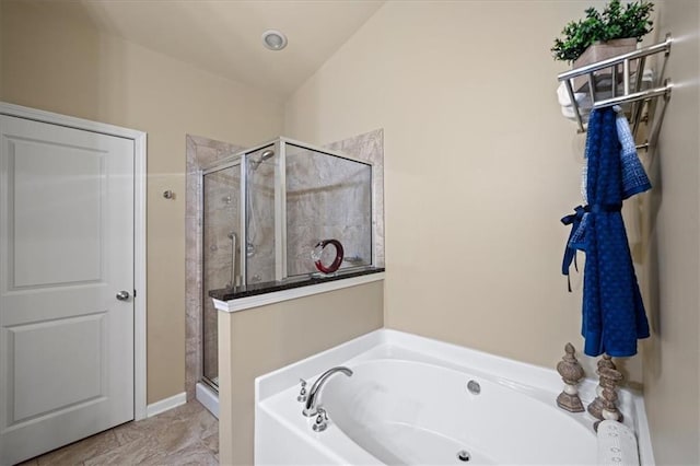 full bathroom with a shower stall and a bath