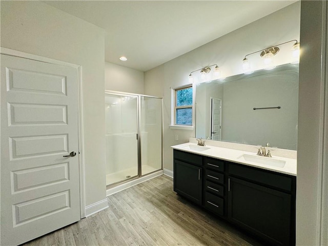 bathroom with vanity, wood-type flooring, and a shower with door